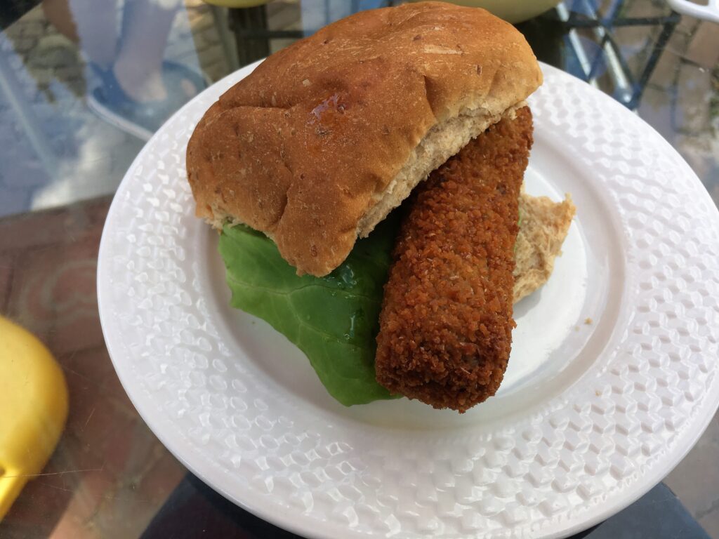Broodje Kroket with some lettuce on a white plate