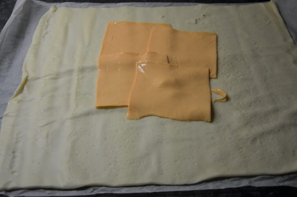 First layer of cheddar on pizza dough