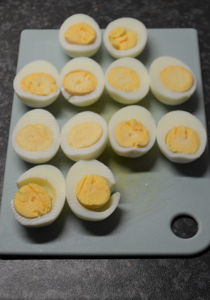 Boiled, peeled and halved eggs  ready on a cutting board