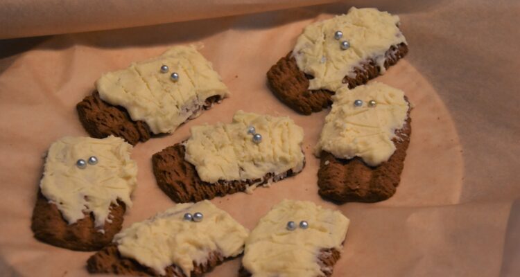 Mummy Cookies, on parchment paper on a plate