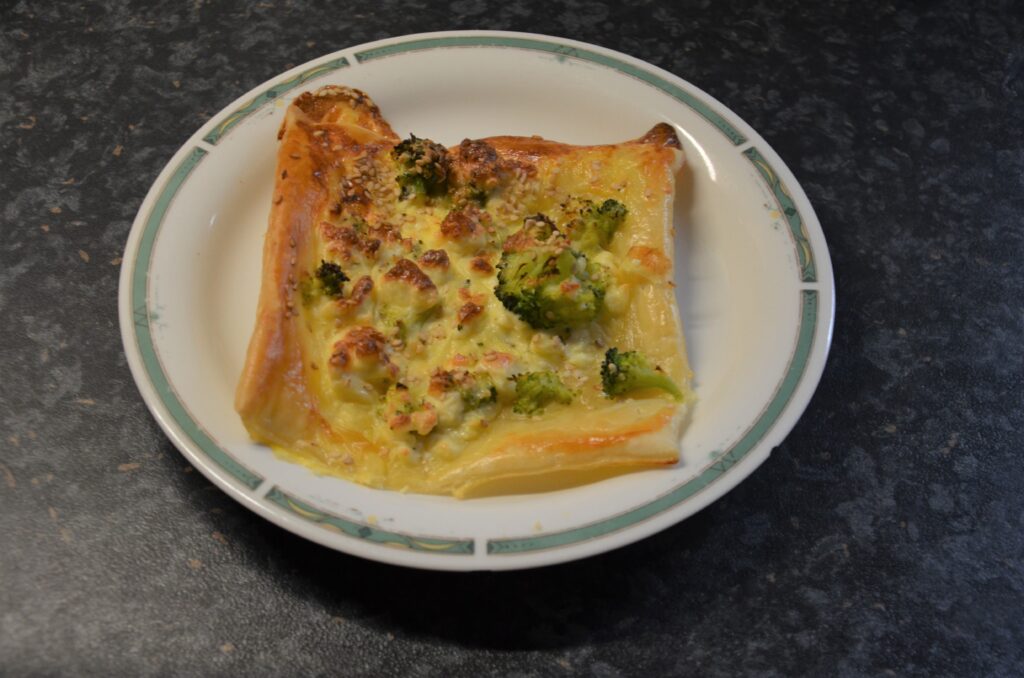 Broccoli and Feta Puff Pastry, without the second sheet on top, served on a white plate