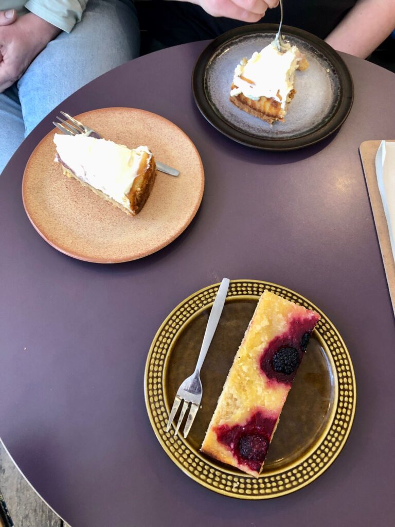 Strawberry cheesecakes and the butter cake, 3 small plates in different colors on a round table as seen from above