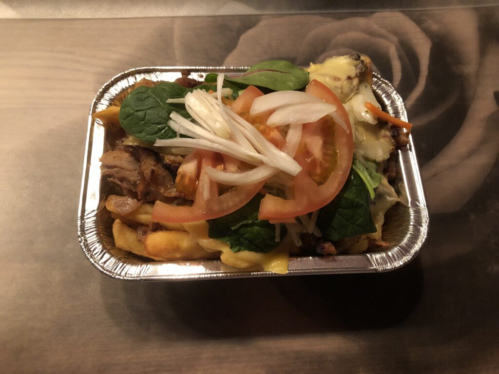 Kapsalon, loaded fries with salad and doner meat in a alu tin foiltray