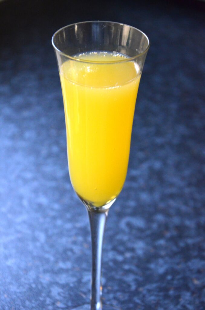 Mimosa recipe, a champagne flute with the alcoholic beverage. Yellow colored