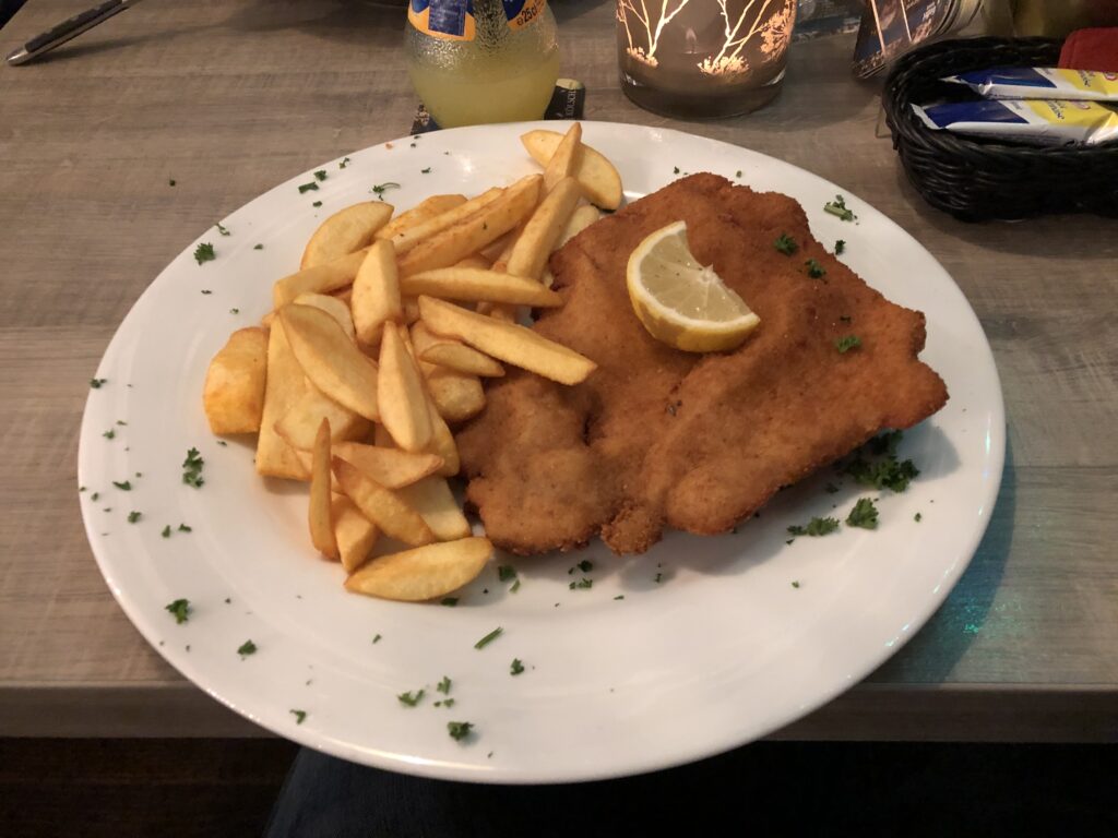 Schnitzel with fries, served on a white plate